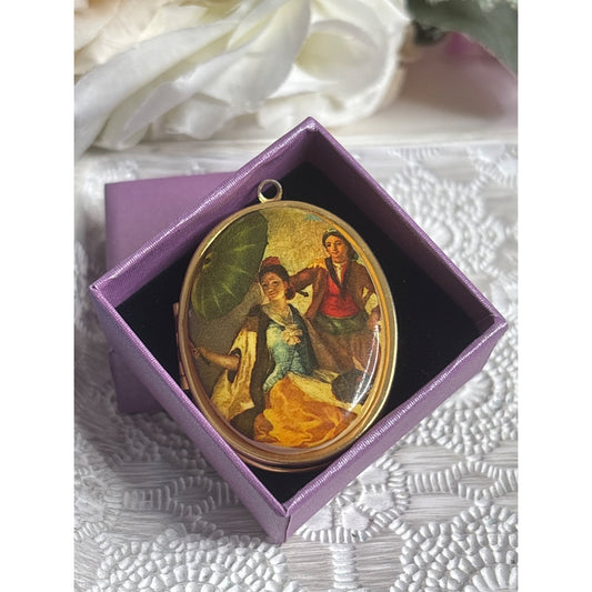 Vintage Gold Tone Oval Locket With Painted Scene Of Couple & Umbrella Hinged Design Holds Two Photos